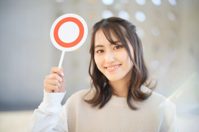 マルのサインを出す女性