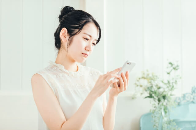 スマホを見て悩んでいる女性