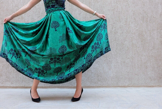 華やかな緑色のスカートを着た女性